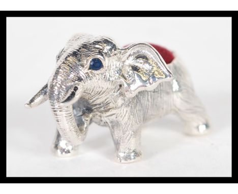 A sterling silver pin cushion in the form of an elephant having red baize pin cusion to top. Weighs 22 grams.