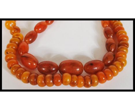 Two vintage 20th Century chinese Amber type prayer bead necklaces, one having circular disc beads and the other graduating el