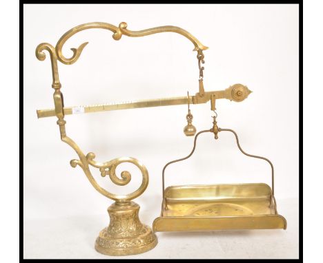 A large and impressive 19th Century French brass set of weighing scales raised on pedestal relief scrolled base with scrolled