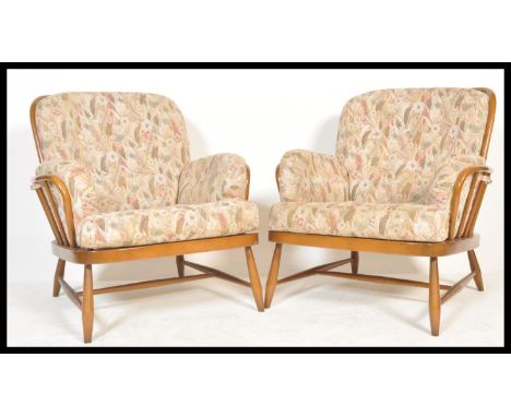 Ercol - A golden dawn Windsor pattern pair of armchairs in beech and elm having shaped  armrests and spindle back rests. cush