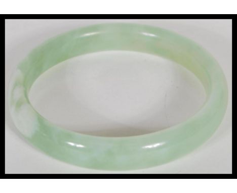 An early 20th Century Chinese carved green stone jade type bangle of circular form. Inside measures 7cm diameter.&nbsp;&nbsp;