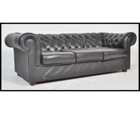 A contemporary black leather button back three seater Chesterfield sofa&nbsp;with button back and scrolled arms on turned sup