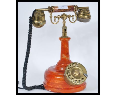 A vintage retro 20th Century ring dial stick telephone having orange stone effect body with ring dial to front and phone mout