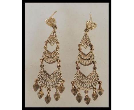 A pair of 9ct gold filigree ladies drop earrings constructed from three graduating sections with scrolled detailing. Stamped 
