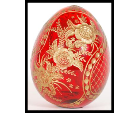 A vintage 20th Century Russian cranberry red glass egg having beautiful hand gilded decoration depicting flowers and leaves. 