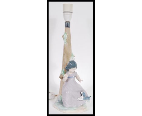 A Lladro Nao ceramic figurine table lamp in the form of a girl playing with a dog, Printed and impressed marks to base. 36cm 