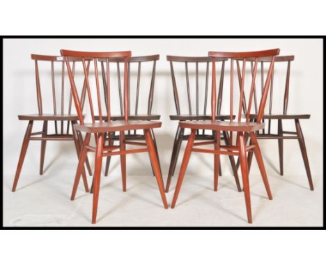 A set of six Ercol vintage 20th Century spindle back beech and elm dining chairs, solid seat pads raised on tapering supports