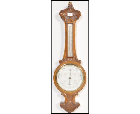 A vintage early 20th Century oak cased Aneroid Banjo barometer with carved detailing, white enamel dial.&nbsp;Measures: 84cm 