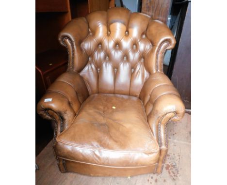 A brown Chesterfield style single armchair, with button back.