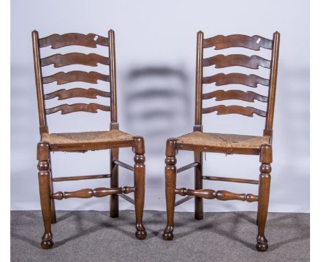 Four ladder-back dining chairs, with rush seats.