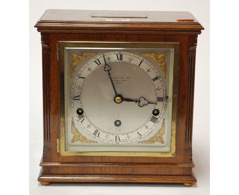 A mid 20th century walnut cased mantel clock by Eliot of London having a silvered dial with Roman numerals within gilt spandr