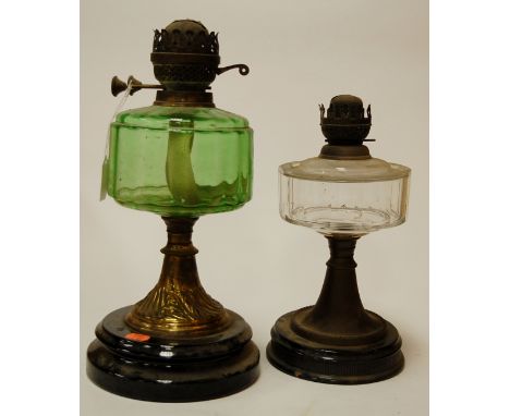 An early 20th century brass pedestal oil lamp having a filled glass shade above a glass reservoir together with two other lam