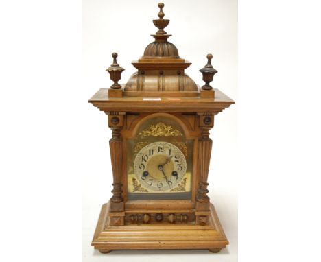 A late 19th century Continental walnut cased mantel clock having brass arched dial with silvered chapter ring and Arabic nume