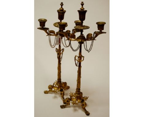 A pair of circa 1900 French gilt metal japonisme three-light candlesticks, having slender leaf capped columns, and on hipped 