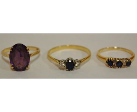 A ladies 9ct gold amethyst set dress ring, size S together with two yellow gold sapphire and diamond set dress rings (3)