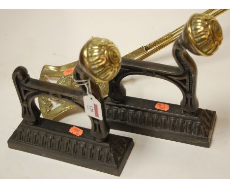 A pair of cast iron and brass mounted firedogs together with turned brass fire tools (4)