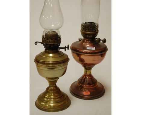 An early 20th century lacquered brass pedestal oil lamp; together with a copper example (2)