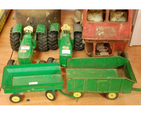 A Ertl green painted model of a John Deere tractor together with trailer, together with one other tractor and trailer, and ti