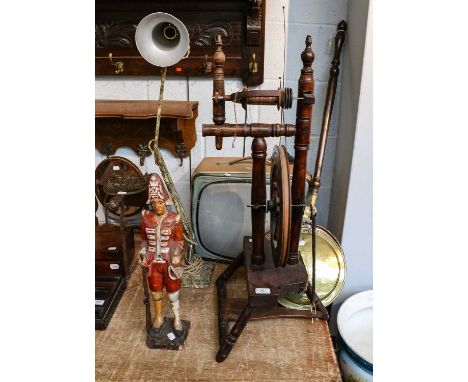 A 19th century spinning wheel, a carved polychrome wood figure of a soldier, a basket containing assorted vintage jigsaws, a 
