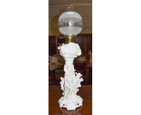 A Moore Brothers oil lamp, white glaze with floral decoration (areas of restoration and damage)