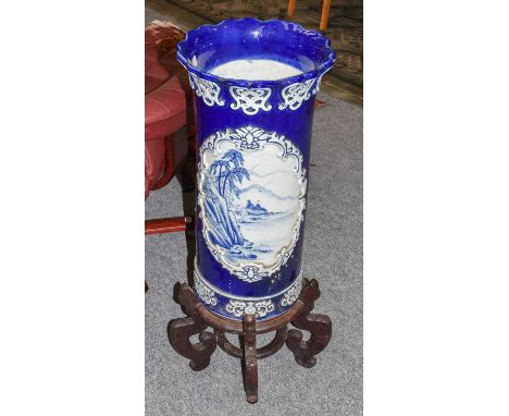 ~ A Japanese Arita cylindrical stick stand, blue ground and with flared rim, 64cm, together with an associated Chinese hardwo