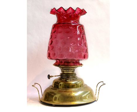 A Victorian brass based oil lamp with cranberry glass shade, 50cm overall