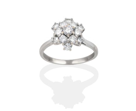 A diamond cluster ring, the snowflake motif set throughout with round brilliant cut diamonds, in white claw settings, to a ta