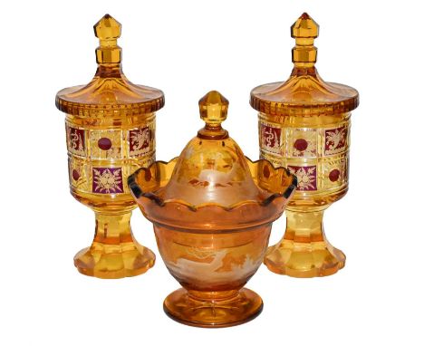 A 19th century Bohemian amber glass bonbonniere etched with a stag and doe in a landscape; together with a similar pair of co