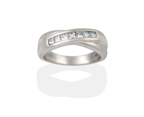 A platinum diamond ring , a row of princess cut diamonds in a channel setting intertwined with a plain polished band, to a pl