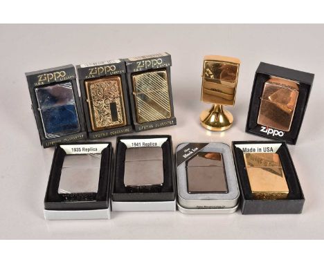 An assortment of various Zippo Lighters, to include a table lighter, Solid Brass, Black Ice, 1935 Replica, 1941 Replica, Vene