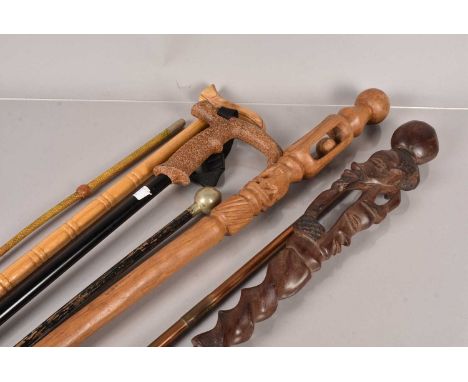 Two carved wooden Tribal Staffs, one having internal ball design, together with a Cameronians swagger stick, a brass trumpet 