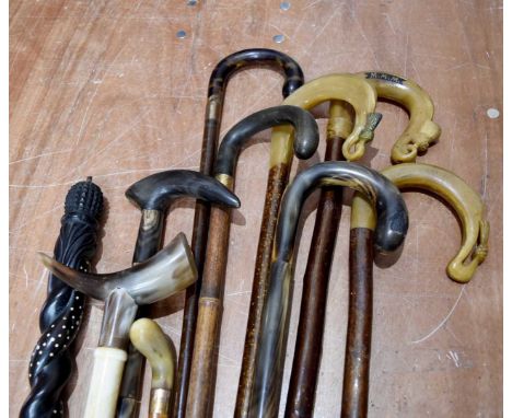 A collection of horn handled walking sticks, together with an ebony example with an inbuilt compass, and another (parcel)