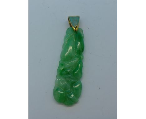 A yellow metal mounted carved jade pendant