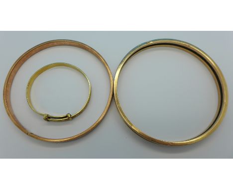 A 9ct gold bangle, 15.6g and two 9ct gold and metal core bangles