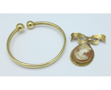 A 9ct gold bangle and a 9ct gold cameo drop brooch with bow clasp, total weight 9.1g