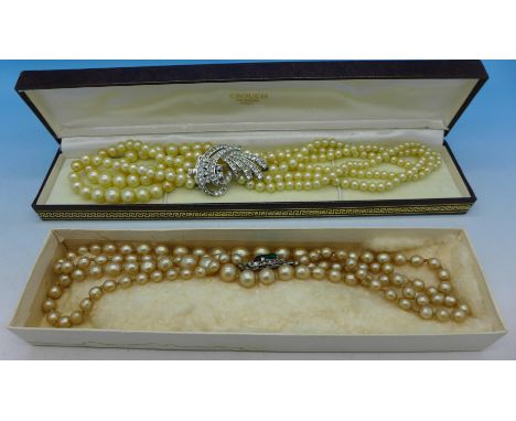 A faux pearl necklace with a silver clasp and a faux pearl necklace with a floral clasp