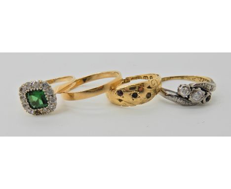 An 18ct wedding ring size P1/2, a 18ct three stone diamond ring (one diamond missing) size L, an 18ct green and clear gem rin