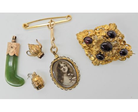 A bright yellow metal garnet set filigree brooch 5.2cm x 3.8cm, weight 10.3gms, a 9ct barrel charm, a yellow metal mounted Ne