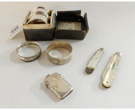 A lot comprising a cased pair of silver napkin rings, a single silver napkin ring, a plated napkin ring, two silver and mothe