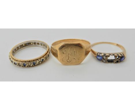 A yellow metal monogrammed signet ring size W1/2, an 18ct sapphire and diamond chip ring (af) size N, and a gem set eternity 