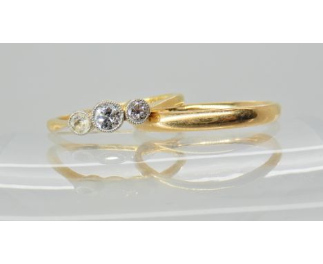 An 18ct diamond ring one of the diamonds has been replaced with a glass gem, finger size M1/2, and a 18ct gold wedding band s