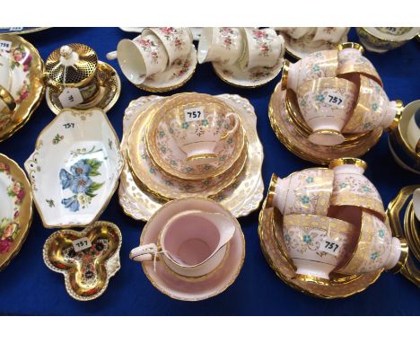 A Tuscan bone china teaset with turquoise enamel flowers and gilt decoration on a pink ground comprising; ten cups, ten sauce