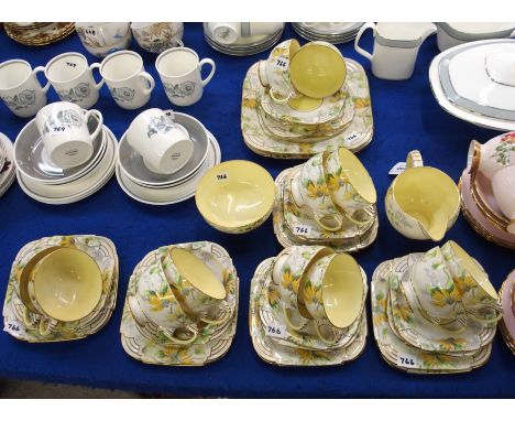 A Paragon fine china teaset decorated with yellow flowers and Deco style handle, comprising; twelve cups, twelve saucers and 