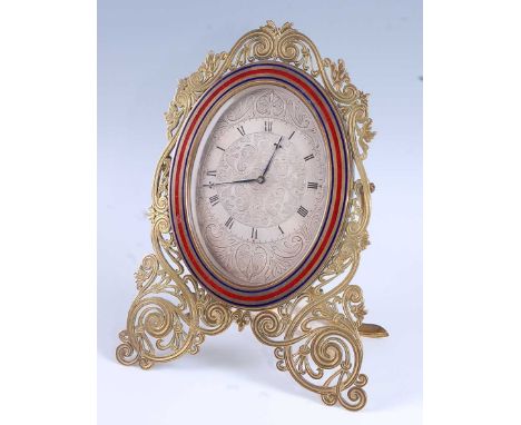 A Victorian cut brass strut clock, circa 1870, having an engraved oval silvered dial with Roman chapter ring, within red and 