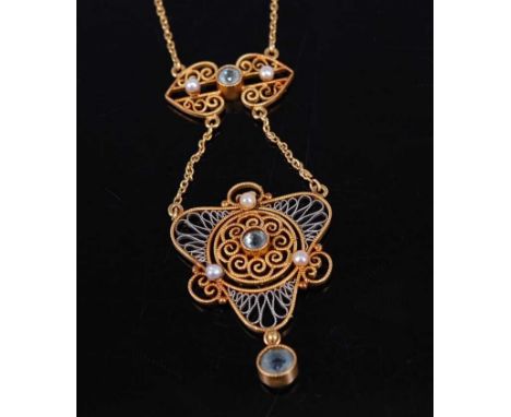 A circa 1920 yellow and white metal openwork pendant of triform, centre set with a small round cut aquamarine within a surrou