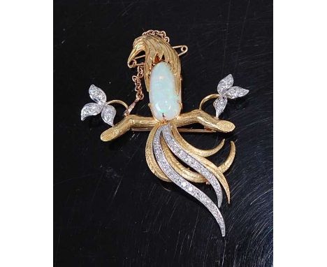 A yellow and white metal, opal and diamond bird brooch, featuring a long-tailed bird with opal cabochon breast perched on a b