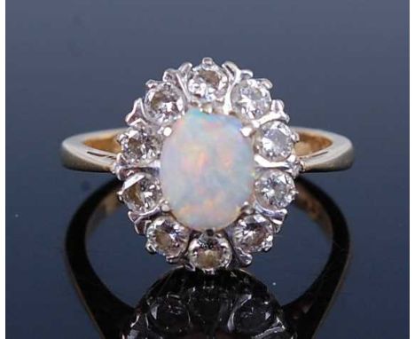 An 18ct yellow and white gold, opal and diamond oval cluster ring, featuring a centre oval opal cabochon within a border of t