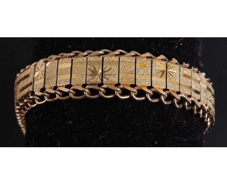 A yellow metal bracelet, having a central textured panel engraved with star detail within an open curblink border, with box c