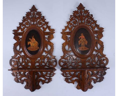 A pair of circa 1900 continental olivewood, marquetry and penwork decorated wall brackets, each being fret carved with hinged