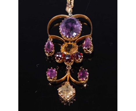 A yellow metal openwork multi-stone pendant, featuring an oval faceted amethyst with two pear cut articulated pink tourmaline